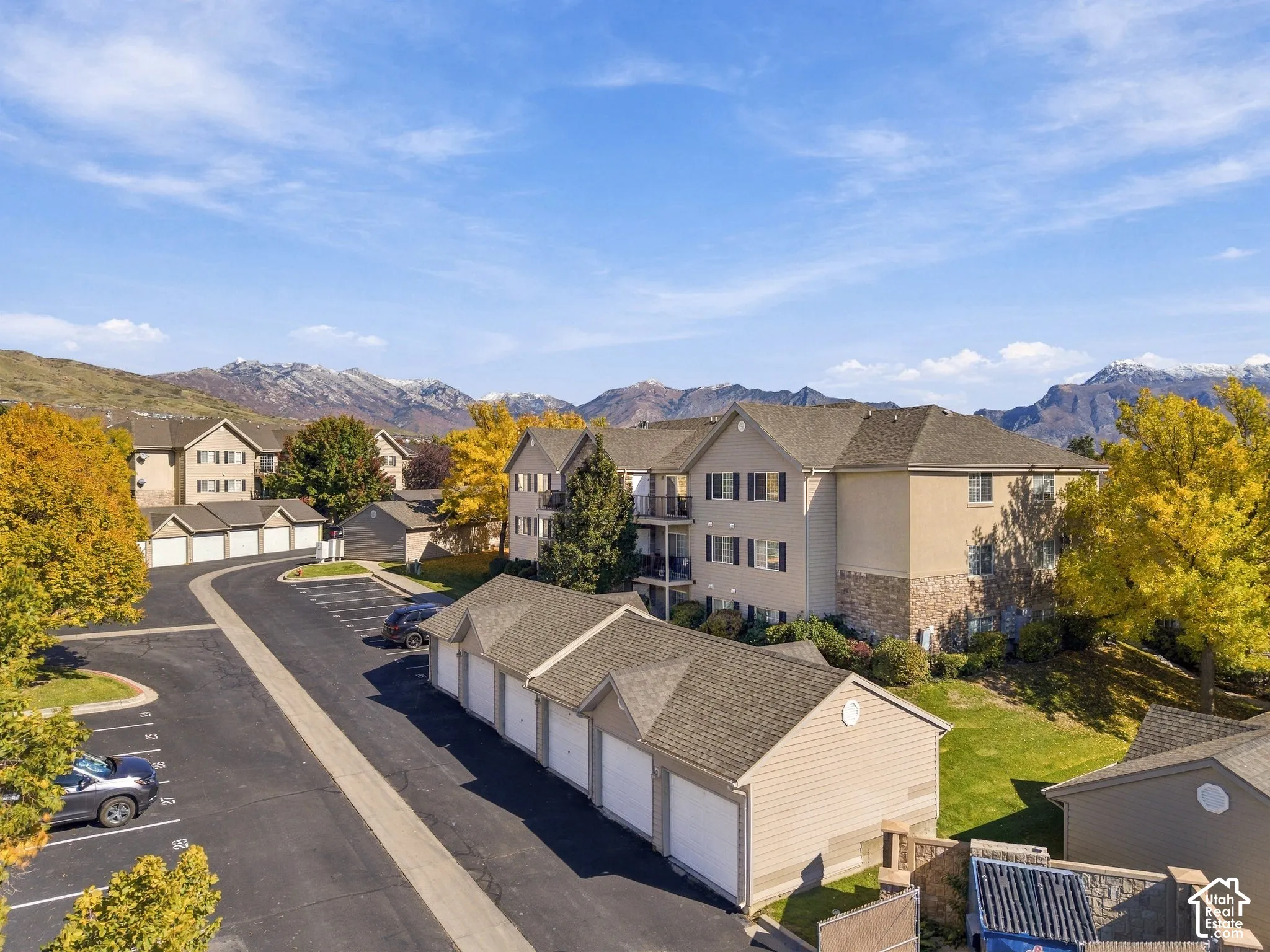 Exterior featuring multi-story siding construction, stone veneer accents, pitched roofing, and detached garage structures set against a mountainous landscape