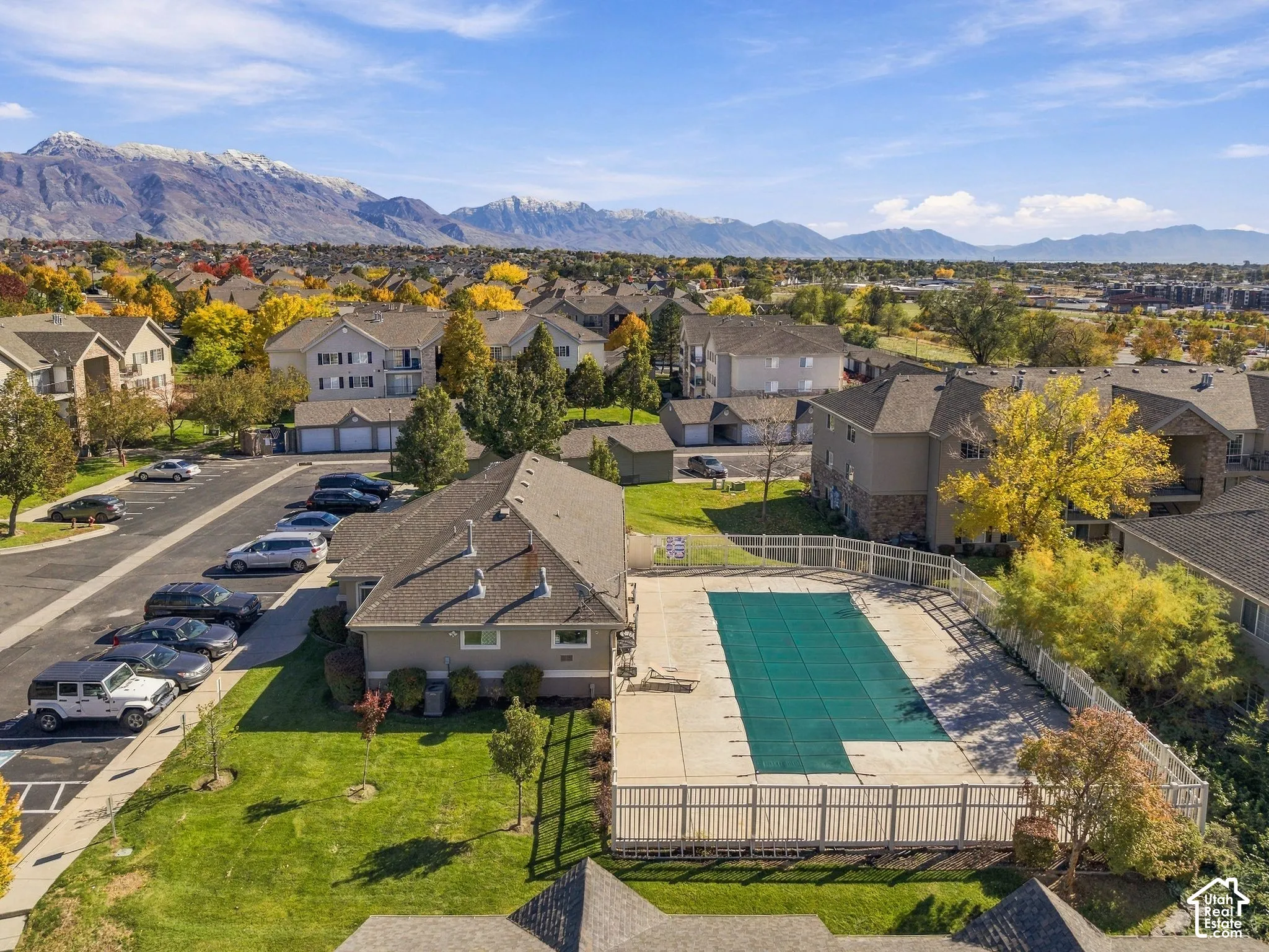 Community pool with concrete decking, fenced perimeter, and mountain backdrop