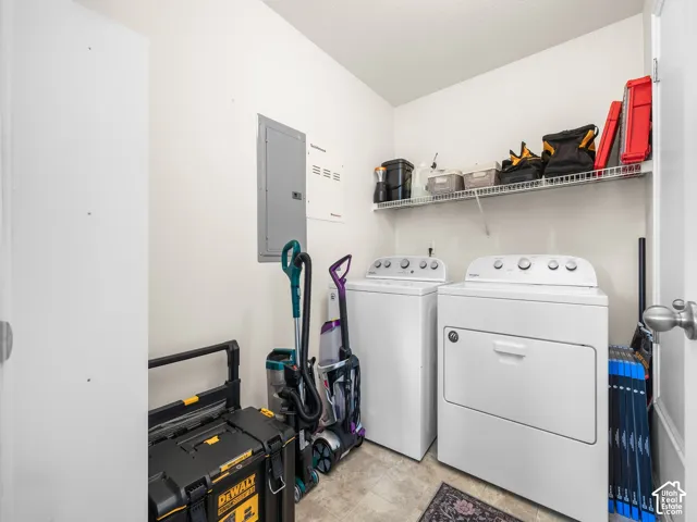 Dedicated utility space featuring a built-in wire shelving system, neutral resilient flooring, and a flush-mounted electrical service panel