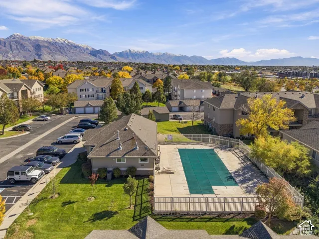 Community pool with concrete decking, fenced perimeter, and mountain backdrop