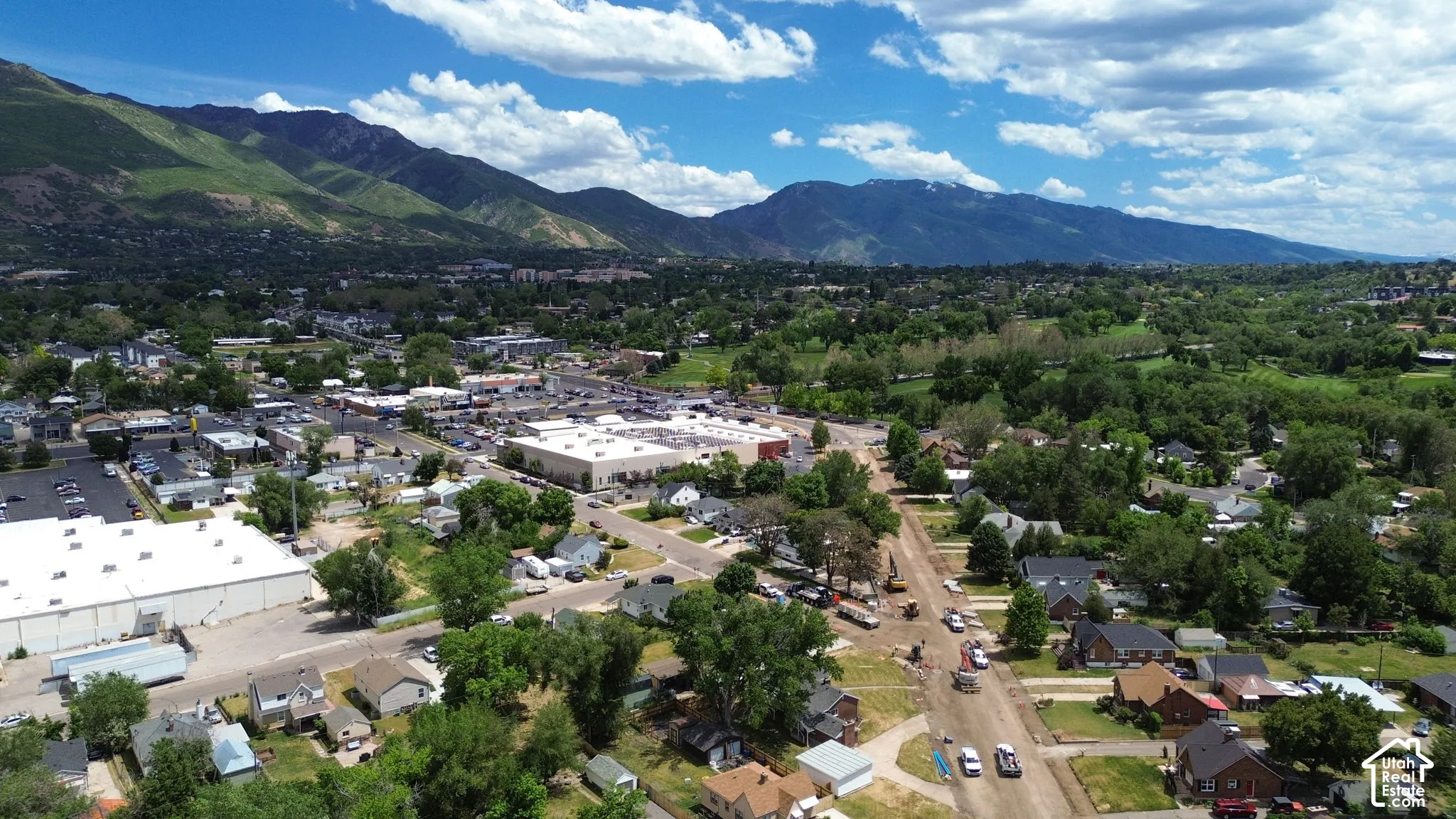 Aerial perspective featuring expansive mountain range backdrop, mature tree canopy, and established neighborhood infrastructure