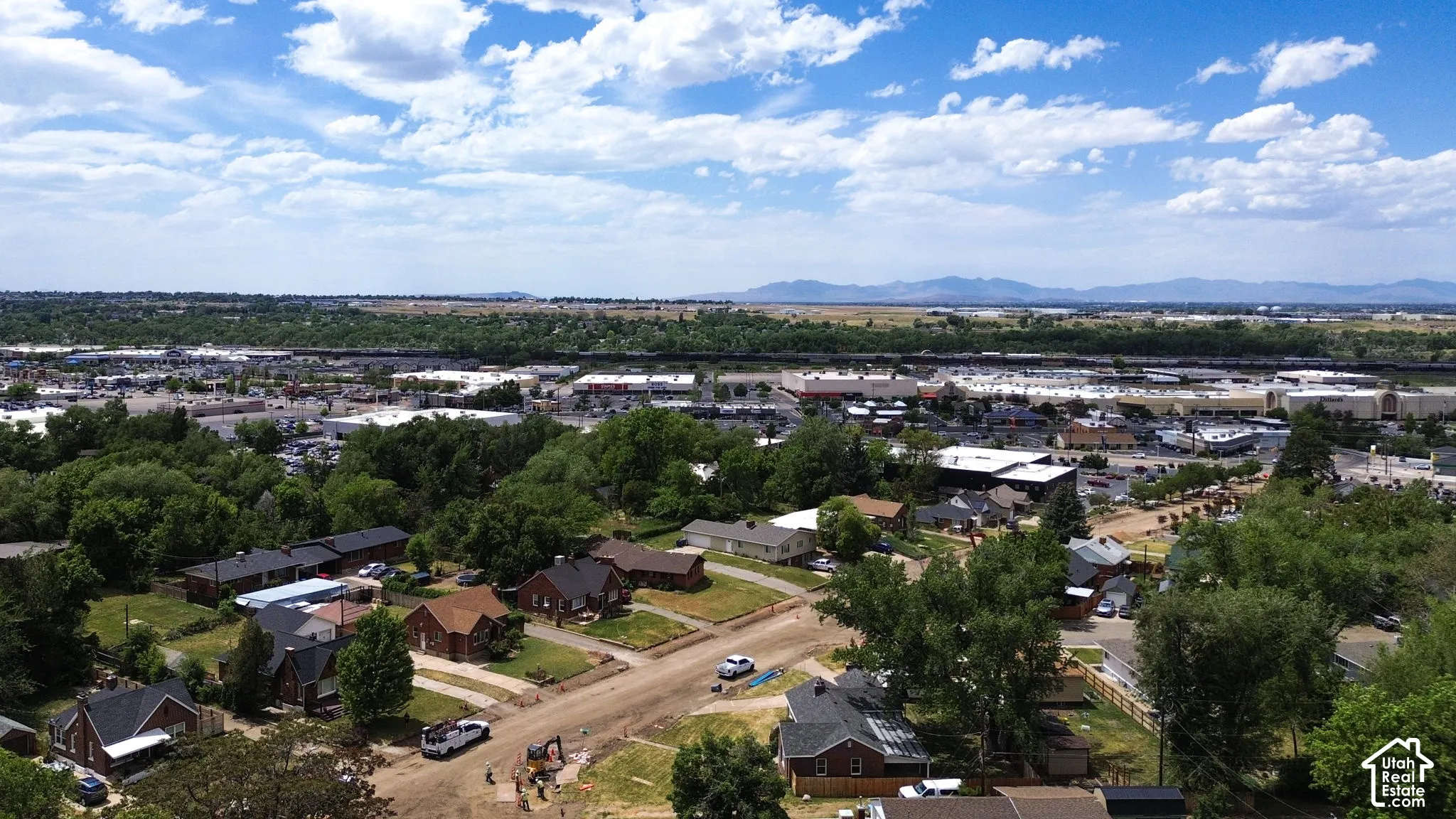 Aerial perspective featuring mature trees, residential streetscapes, and distant mountain topography