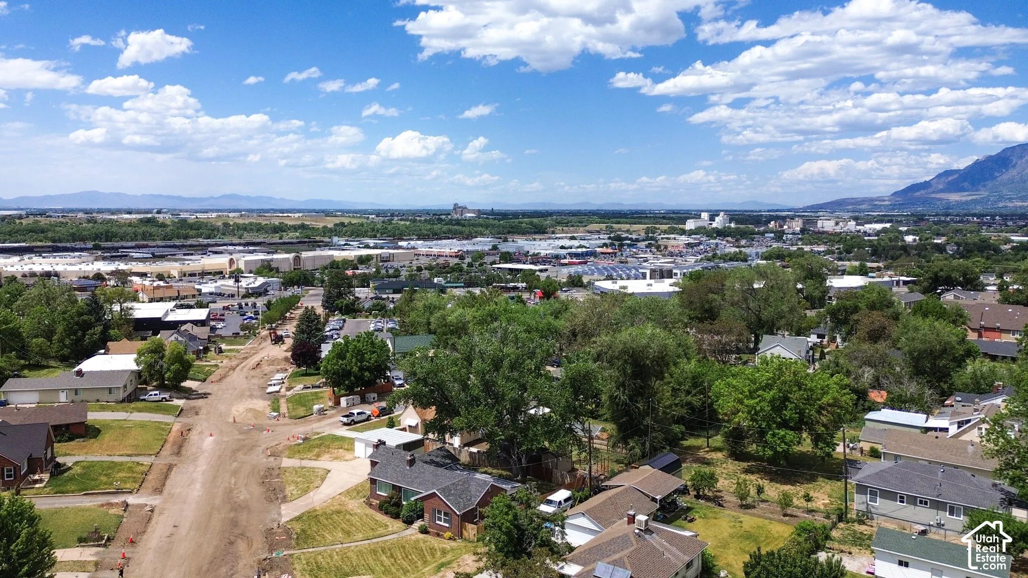 Aerial perspective of the property surroundings featuring mature trees and a mountain backdrop