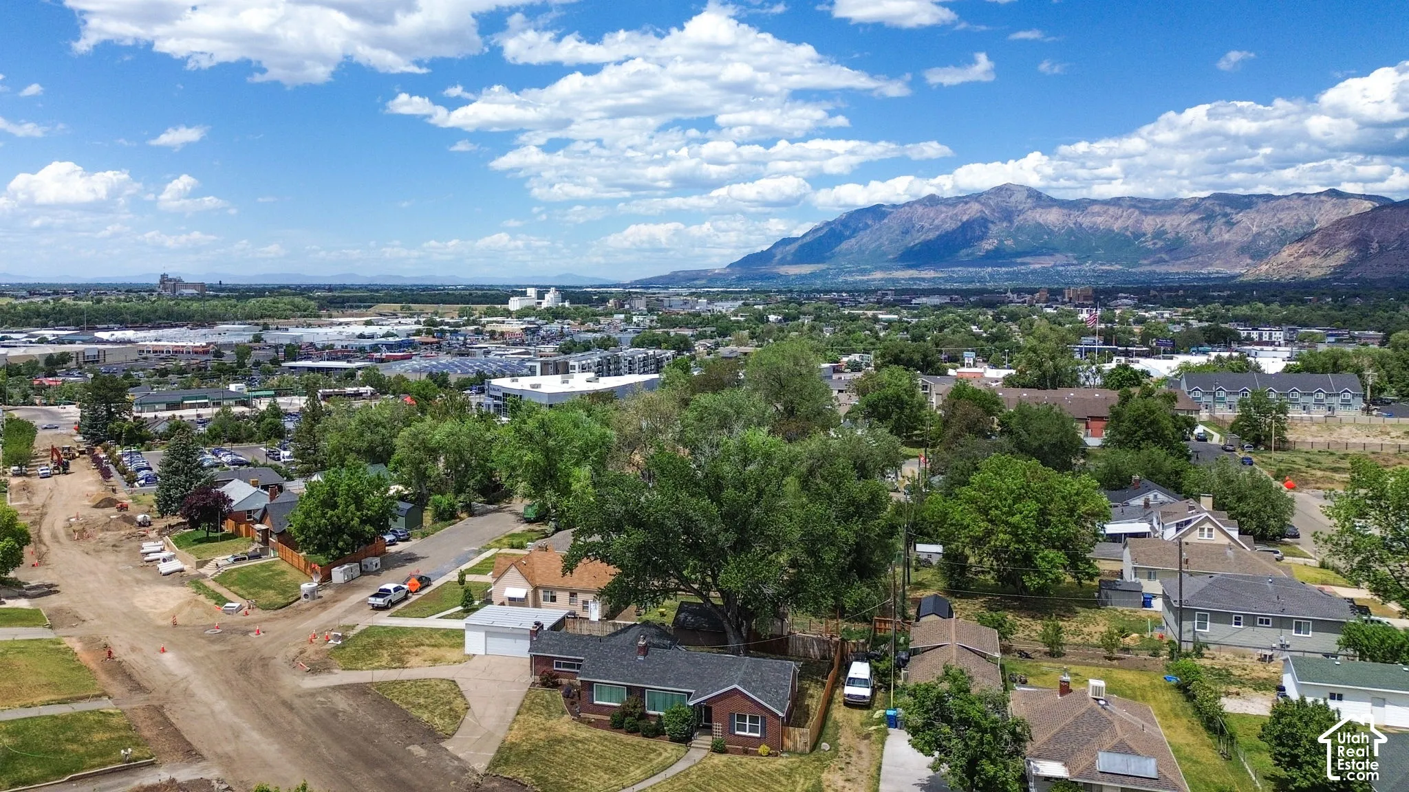 Aerial perspective featuring a single-story brick exterior residence, attached garage, and prominent mountain backdrop