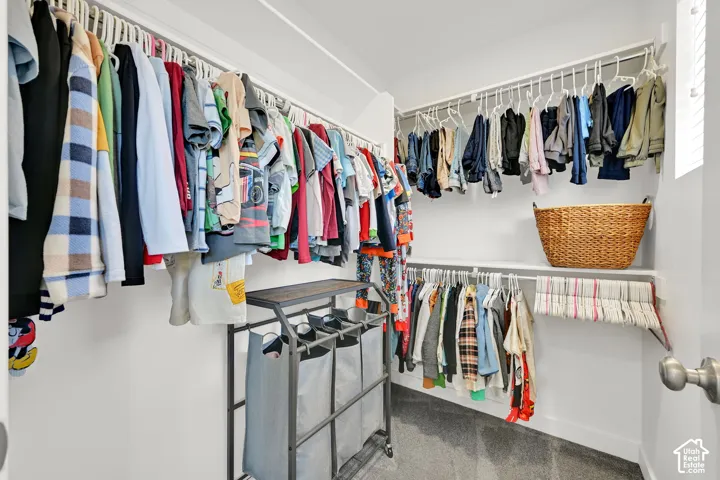 Walk-in closet featuring multi-level white wire shelving and wall-to-wall carpeting