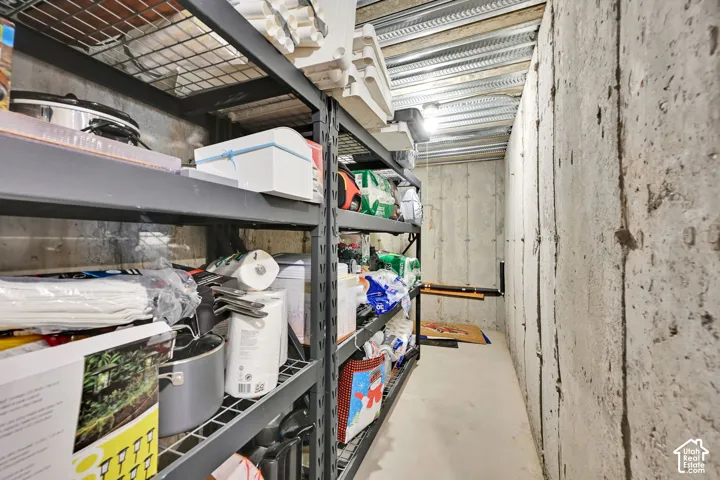Concrete foundation walls with exposed metal ceiling joists and concrete flooring