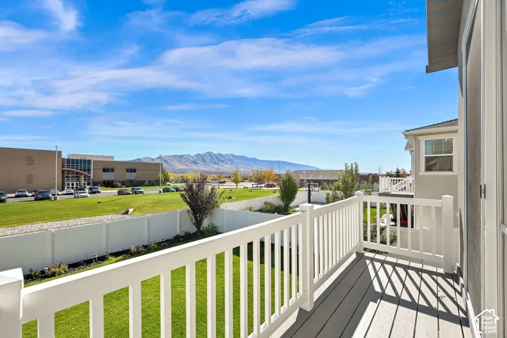 Elevated balcony featuring composite decking, white picket-style railings, and mountain scenery