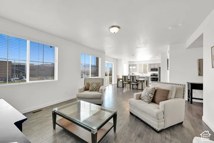 Open-concept interior featuring wood-finish flooring, neutral walls, large windows, and an island kitchen