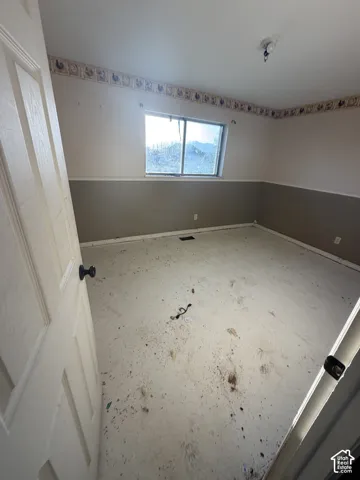 Room featuring a single sliding window, two-tone wall finish, and decorative wallpaper border
