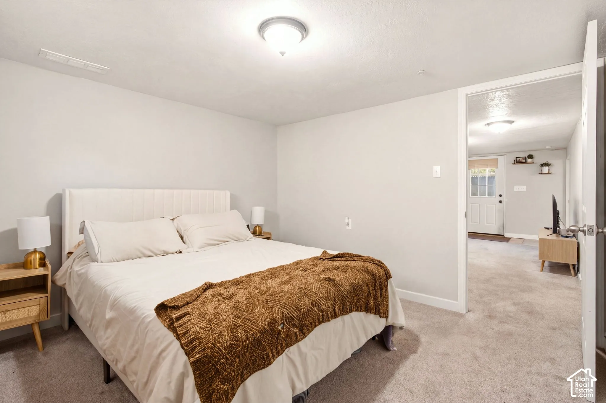 Neutral-toned interior room with wall-to-wall carpeting and a flush-mount ceiling light fixture