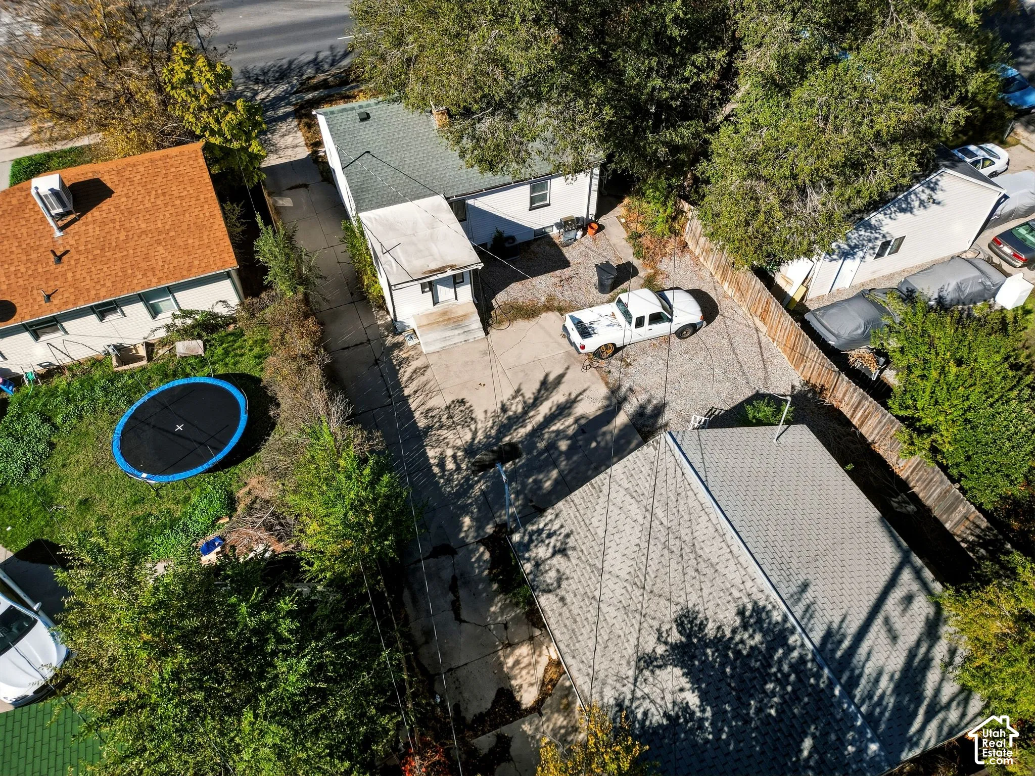 Aerial view of property featuring a detached garage, concrete driveway, and wooden perimeter fencing