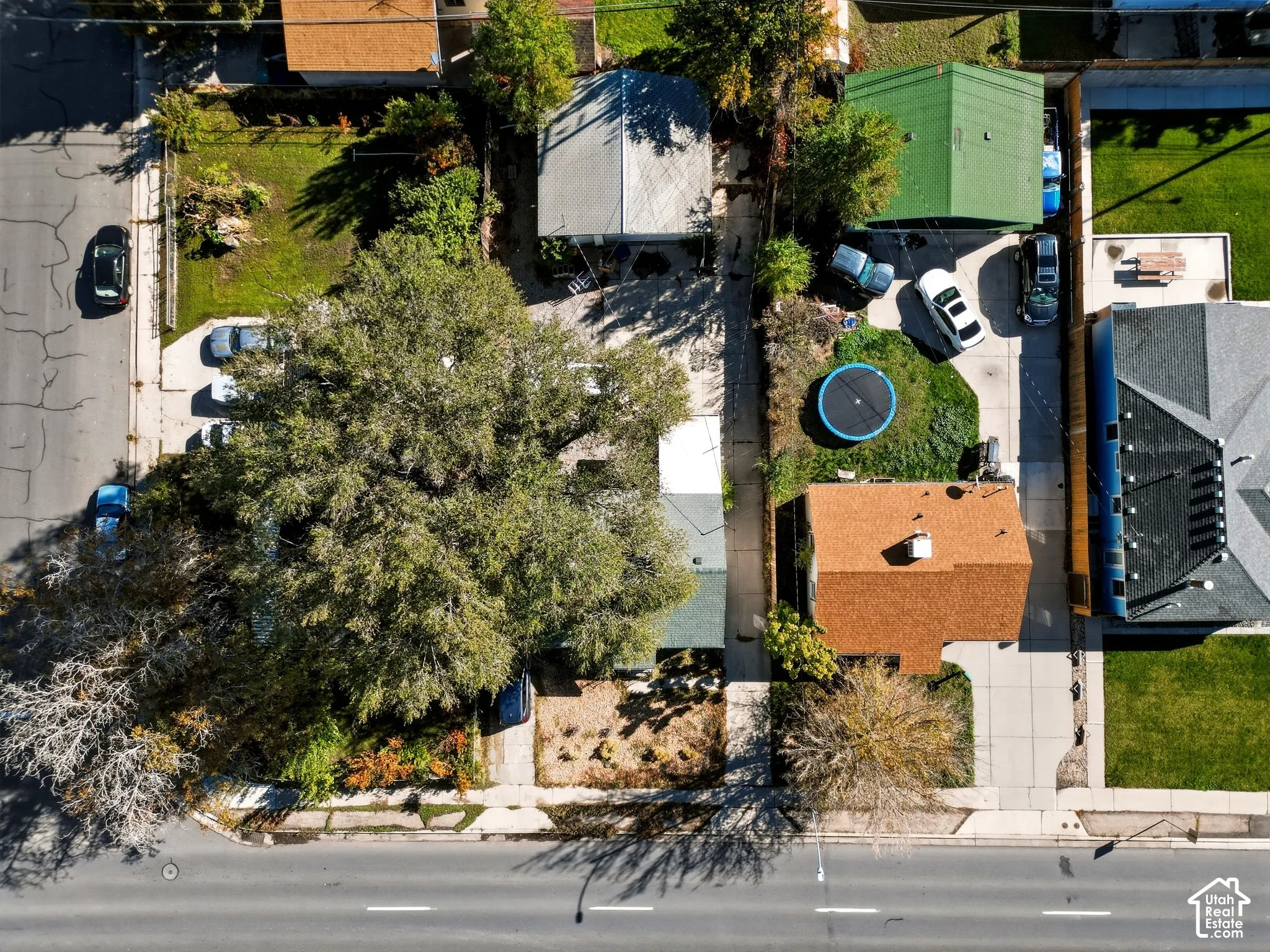 Aerial perspective featuring a property with a concrete driveway and mature trees