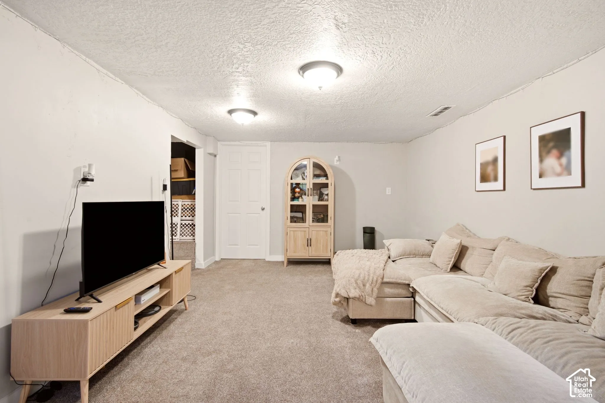 Neutral-toned interior space featuring wall-to-wall carpeting and dual flush-mount ceiling light fixtures