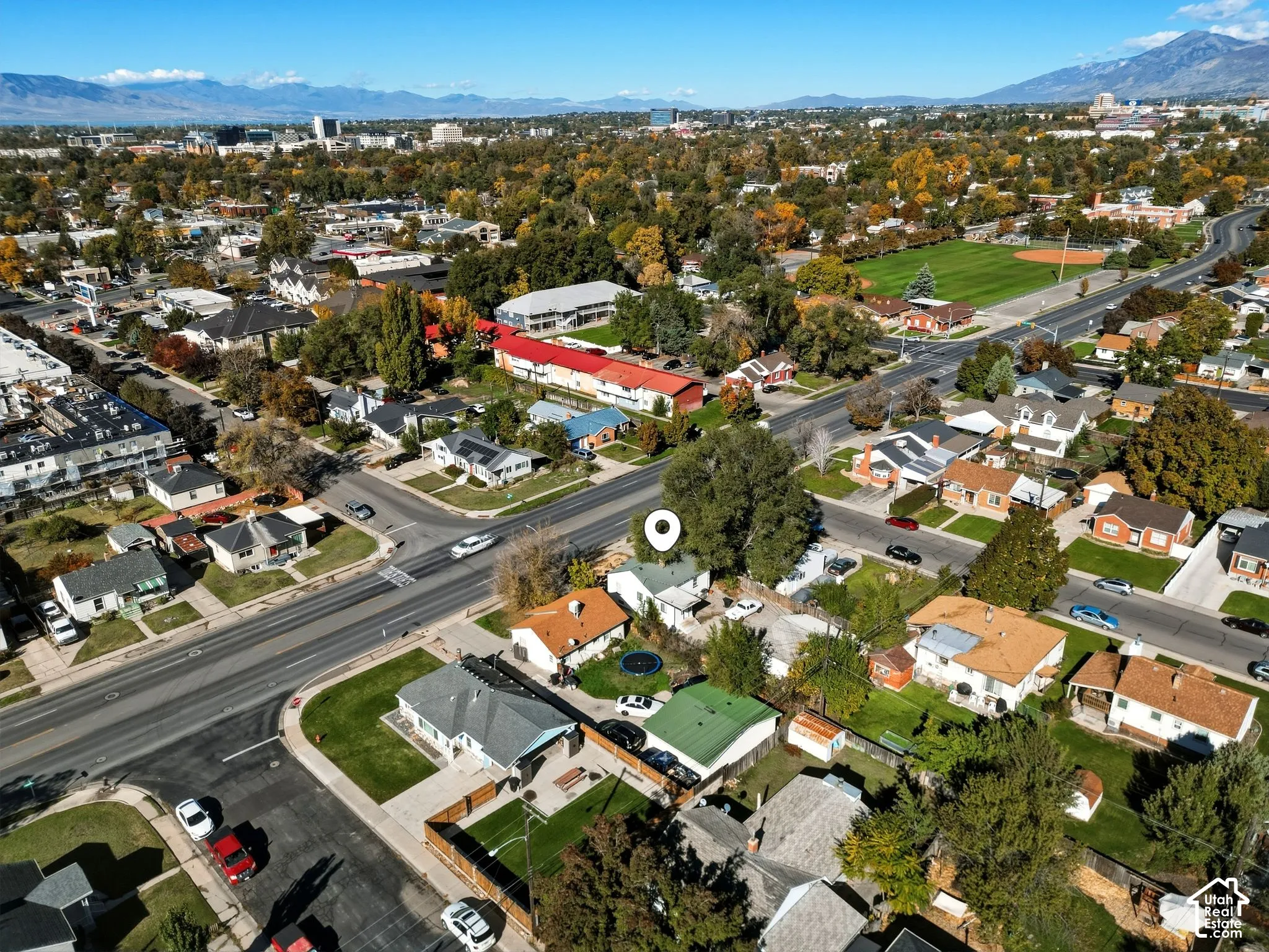 Aerial perspective highlighting residential property with mature trees and mountain range backdrop