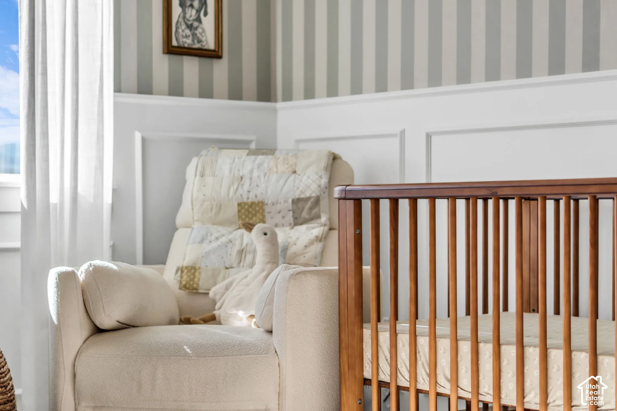 Interior wall featuring white wainscoting, decorative chair rail, and vertical striped wallpaper