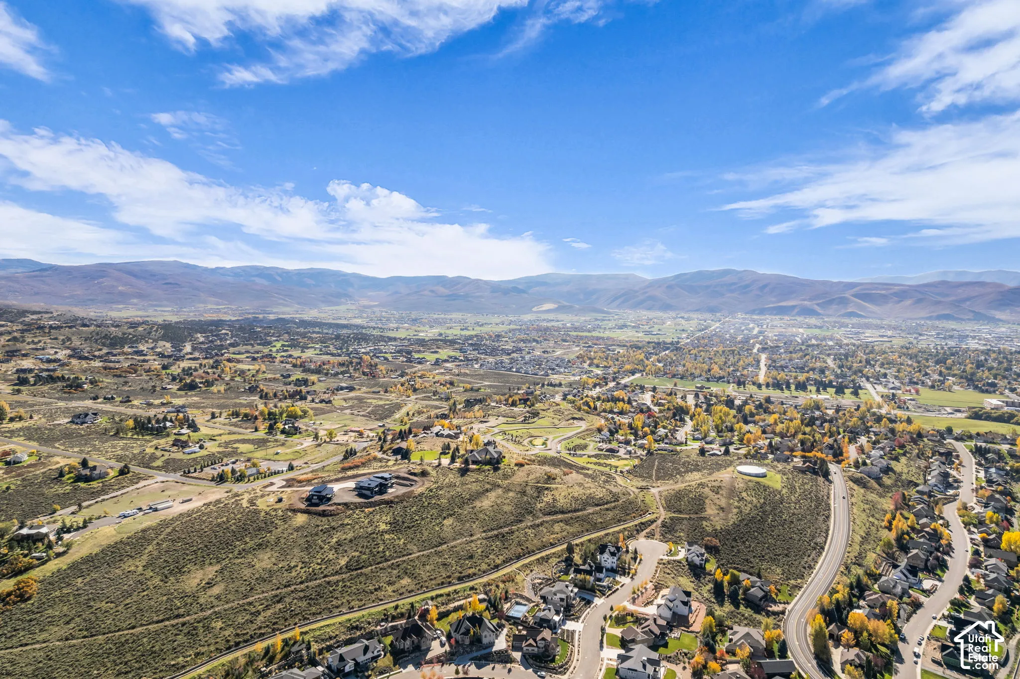 Aerial perspective showcasing expansive terrain, natural brush landscape, and distant mountain topography