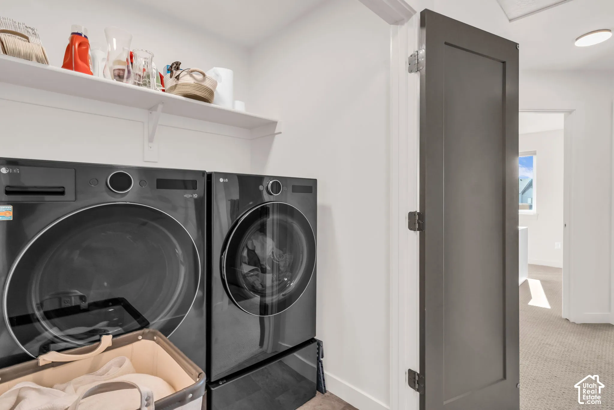 Laundry area featuring built-in shelving and a charcoal-finished interior door