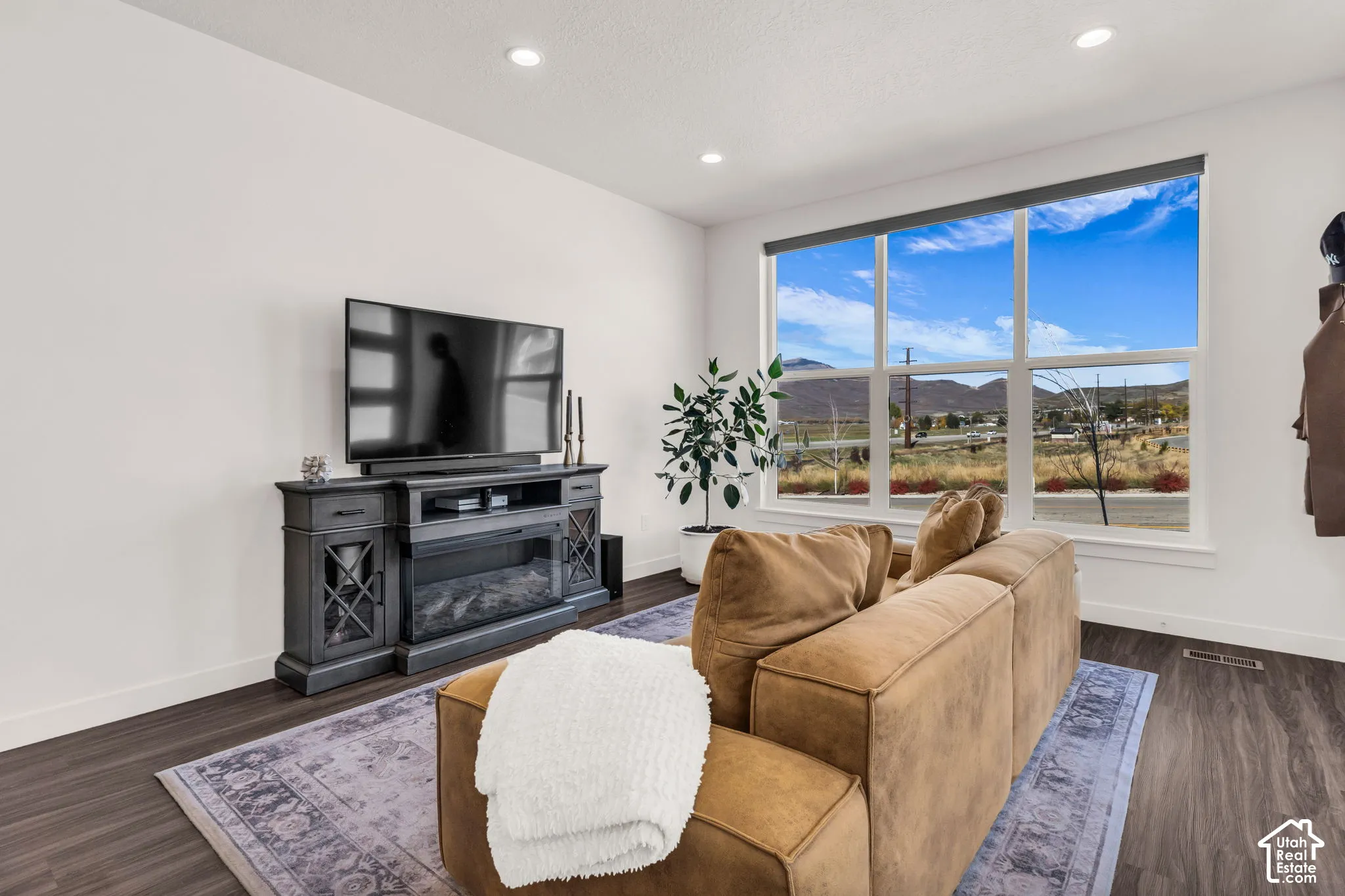 Living space featuring wood-finish flooring, recessed lighting, and large windows with mountain scenery