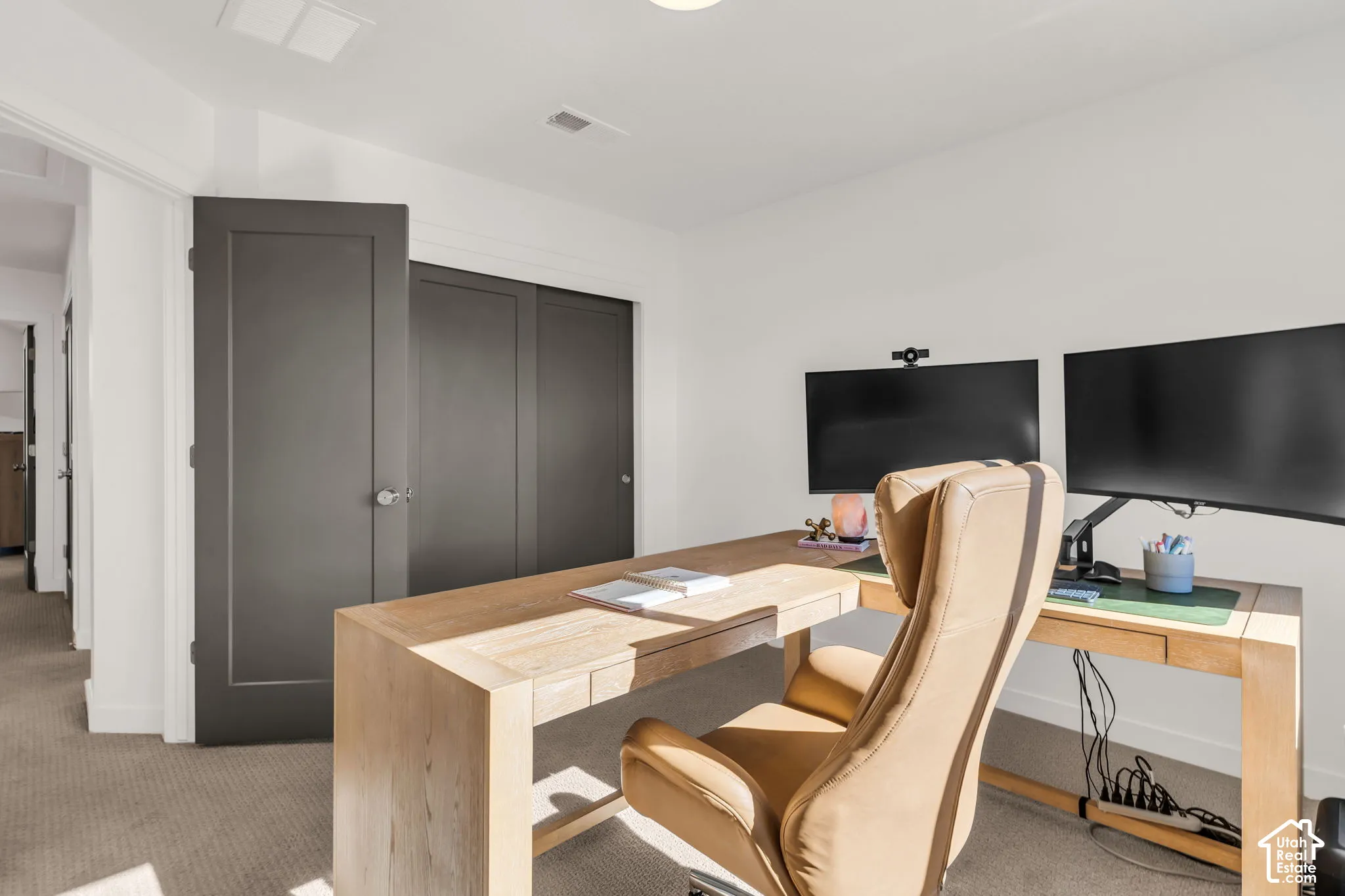 Neutral-toned wall-to-wall carpeting, recessed ceiling lighting, and solid-core interior doors with a charcoal finish