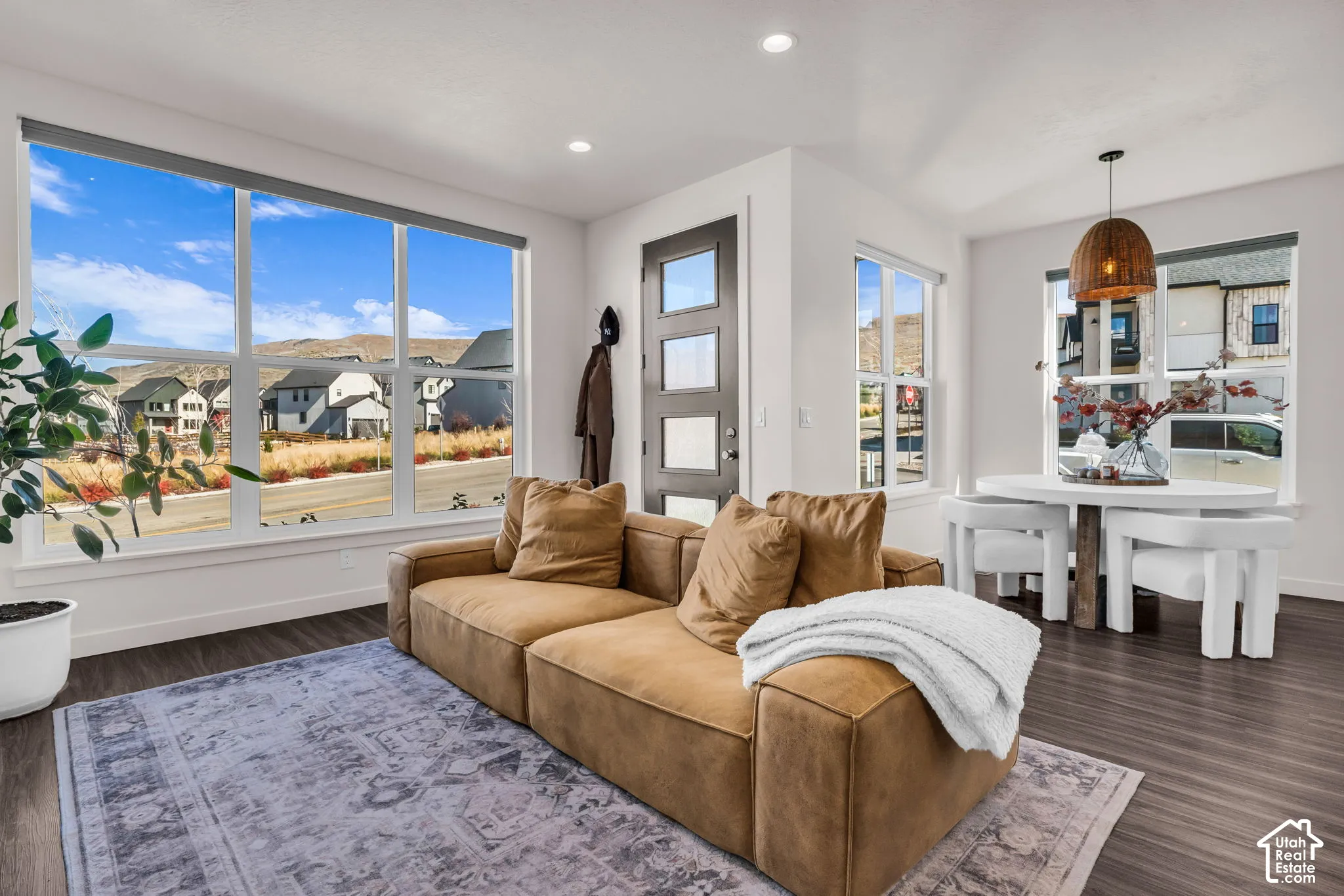 Open-concept living space featuring wood-finish flooring, recessed lighting, and expansive windows