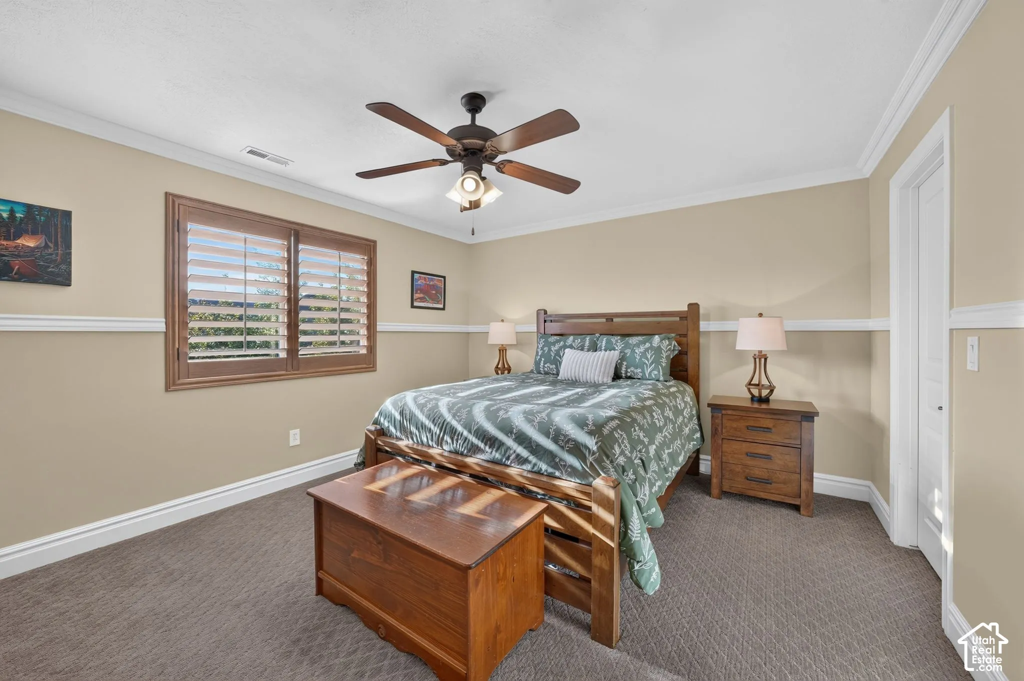 Neutral wall tones featuring chair rail molding, crown molding, wood-finish shutters, and a ceiling fan with integrated lighting