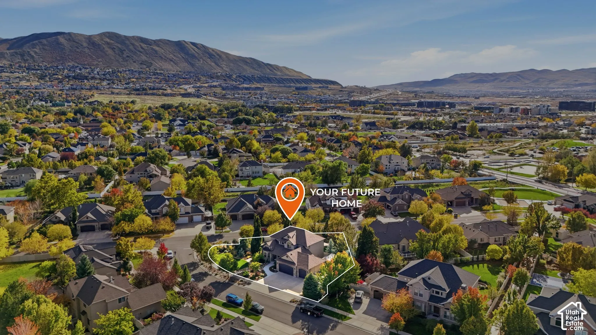 Aerial perspective featuring a multi-gabled roofline, multi-car garage, and landscaped lot set against a mountain backdrop