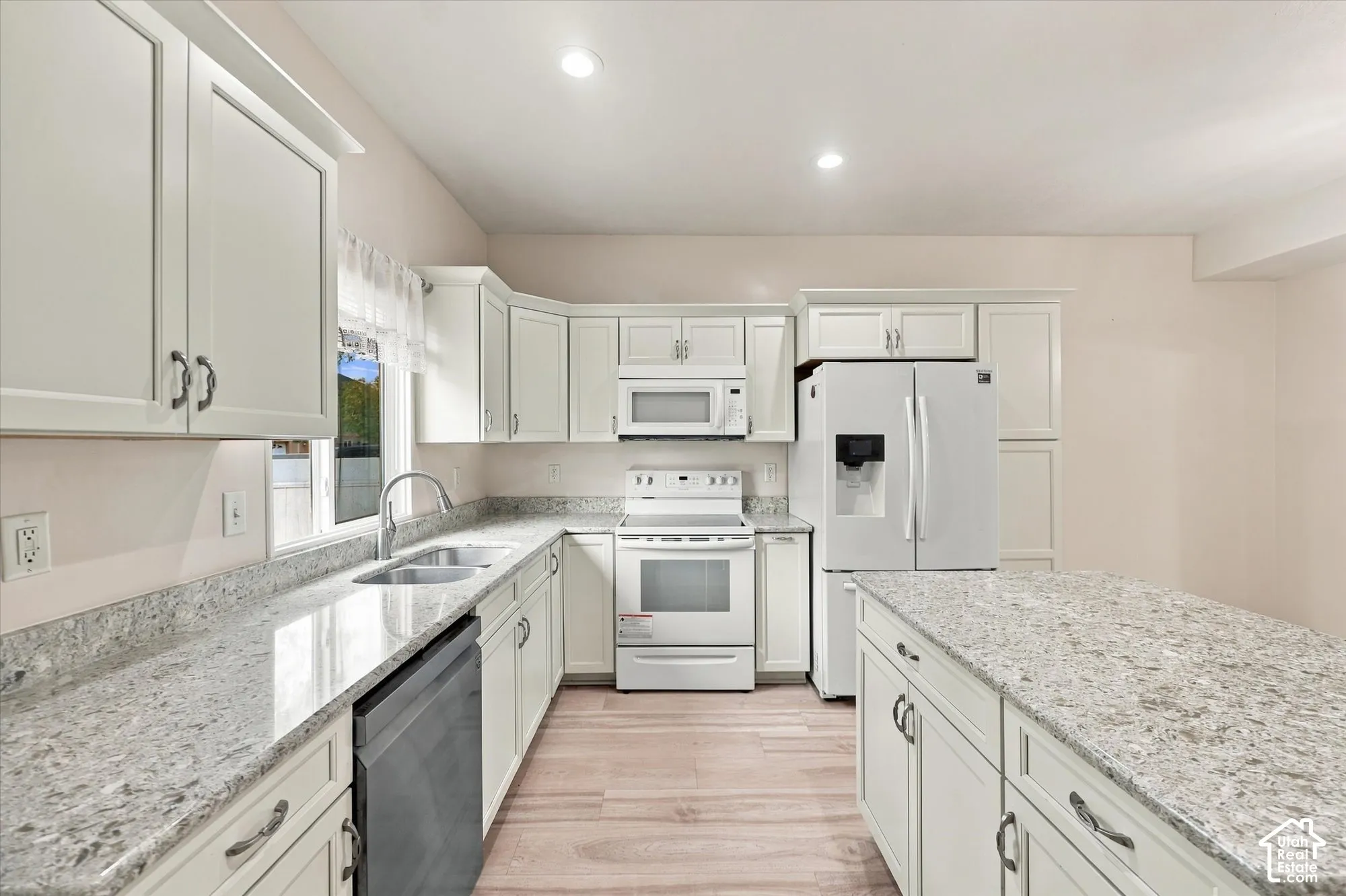 Kitchen featuring white shaker cabinetry, stone-patterned countertops, a central island, recessed lighting, and wood-finish flooring