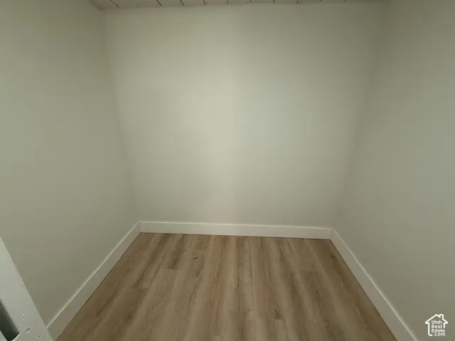 Enclosed space featuring wood-finish flooring and neutral-toned walls