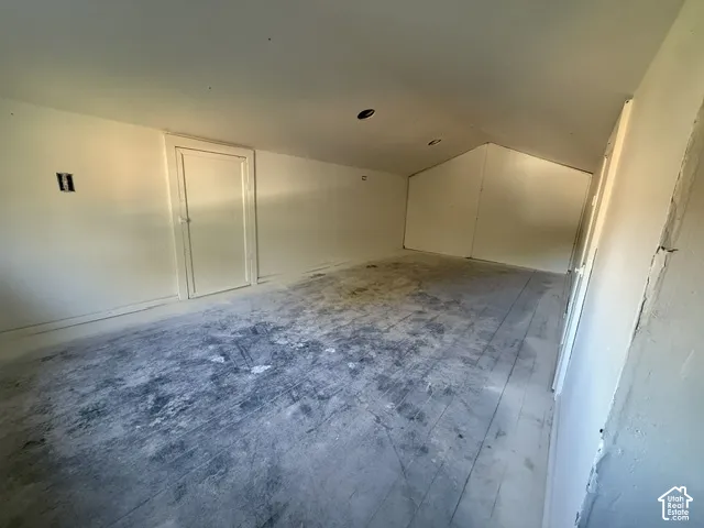 Finished attic space featuring vaulted ceilings, recessed lighting, and wood-plank flooring