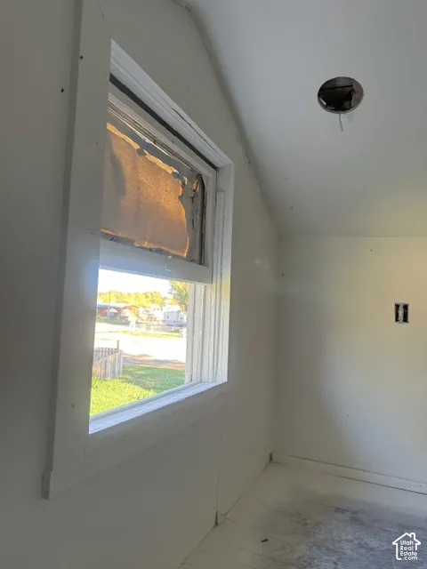 Single-hung window with white wood trim and sloped ceiling