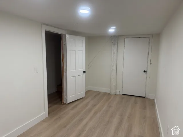 Interior room featuring wood-finish flooring, recessed lighting, and two six-panel doors