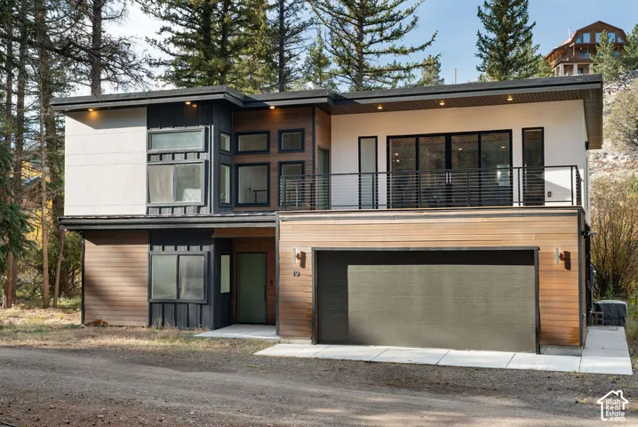 Contemporary multi-level exterior featuring horizontal wood siding, dark vertical board-and-batten siding, a flat roofline, and an upper-level cable railing deck