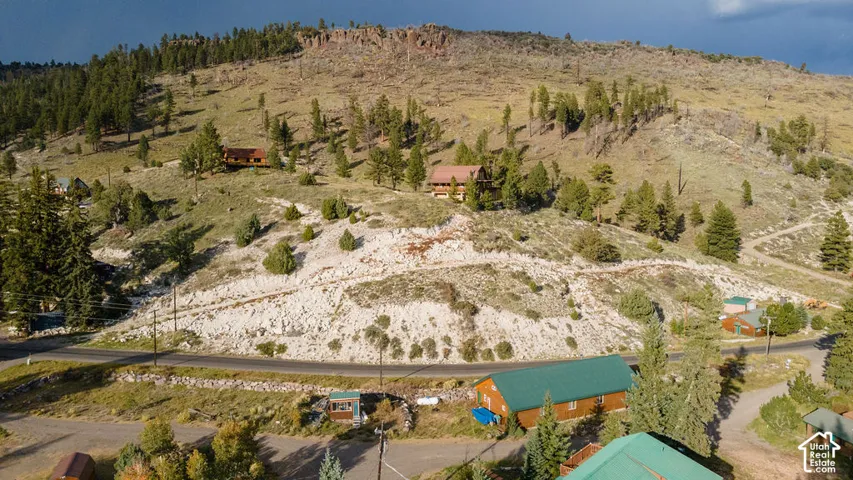 Expansive mountainous terrain with natural rock formations, mature evergreen forest, and elevated topography