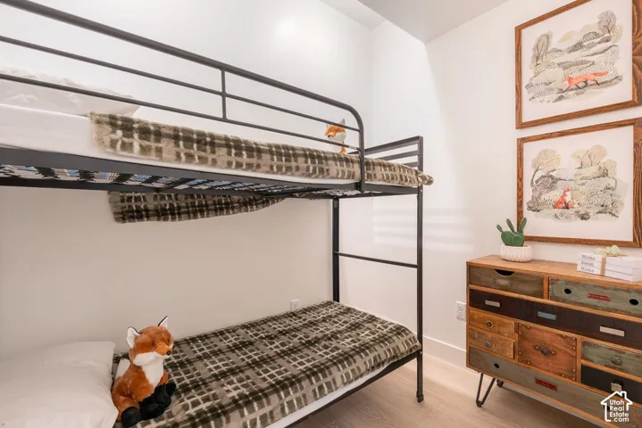 Neutral interior space featuring wood-finish flooring and crisp white wall finishes