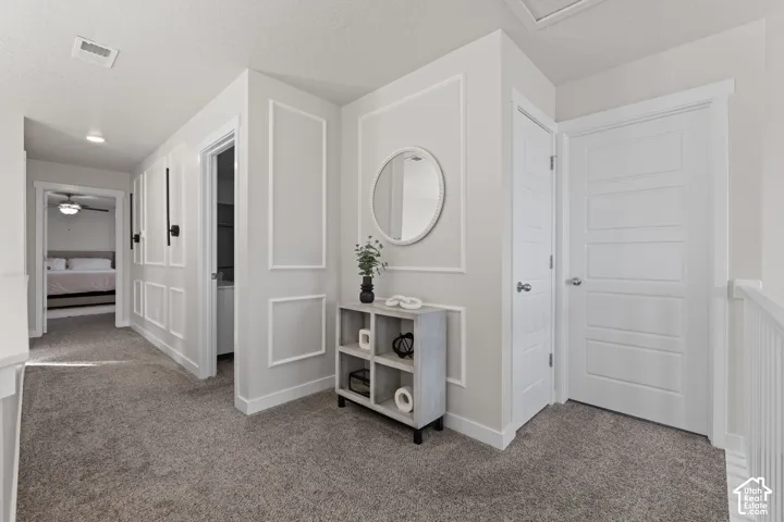 Neutral wall palette featuring custom wall molding, interior doors with five horizontal panels, and wall-mounted light fixtures