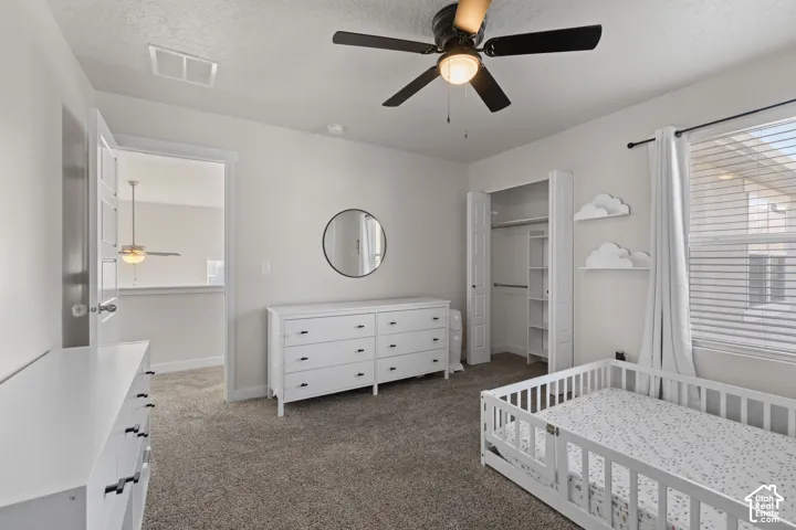 Neutral wall-to-wall carpeting, ceiling fan with integrated lighting, bi-fold closet doors, and window blinds