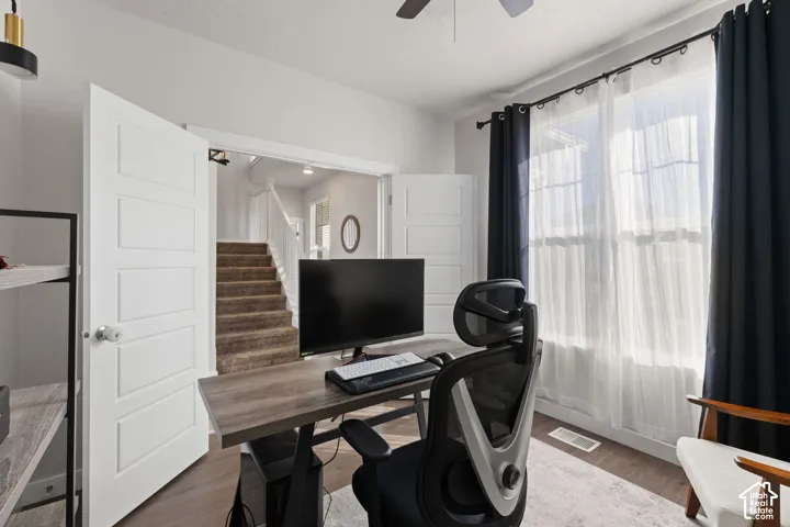 Room featuring wood-finish flooring, double-panel interior doors, and a ceiling fan