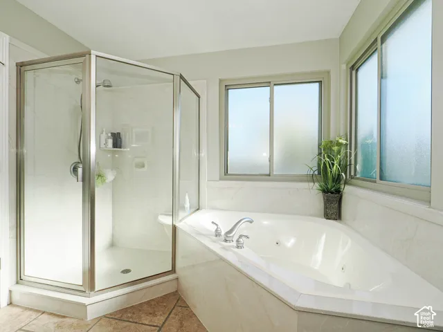 Corner shower enclosure, jetted soaking tub, stone-finish tile surround