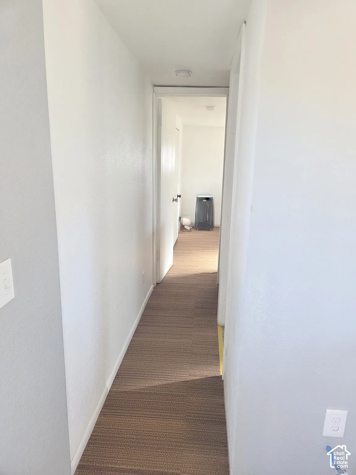 Hallway featuring neutral wall paint, wood-finish flooring, and recessed ceiling lighting