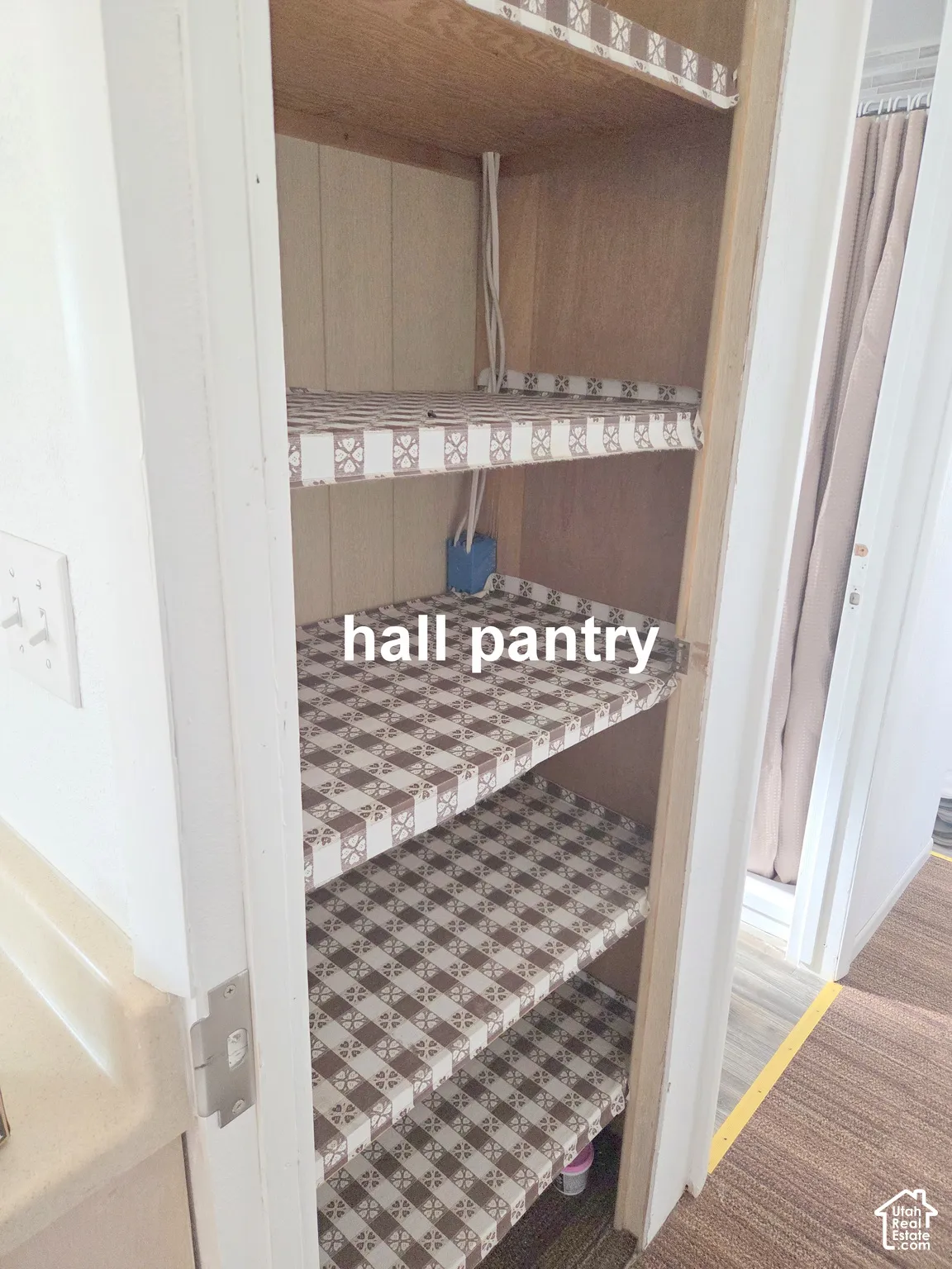 Built-in storage cabinet featuring vertical wood paneling and four integrated wooden shelves