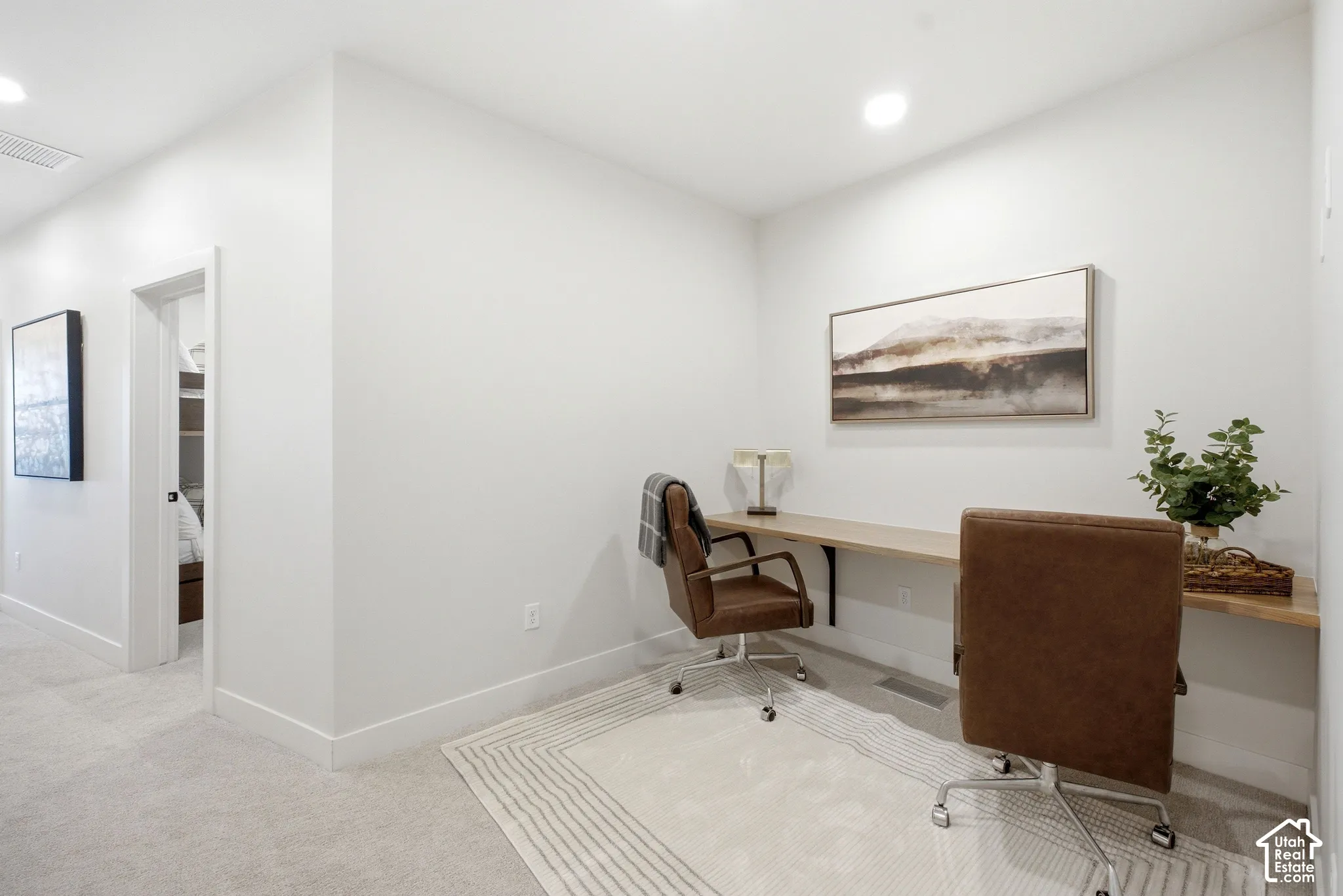 Wall-mounted floating wood-surface desk with integrated bracket supports and recessed ceiling lighting