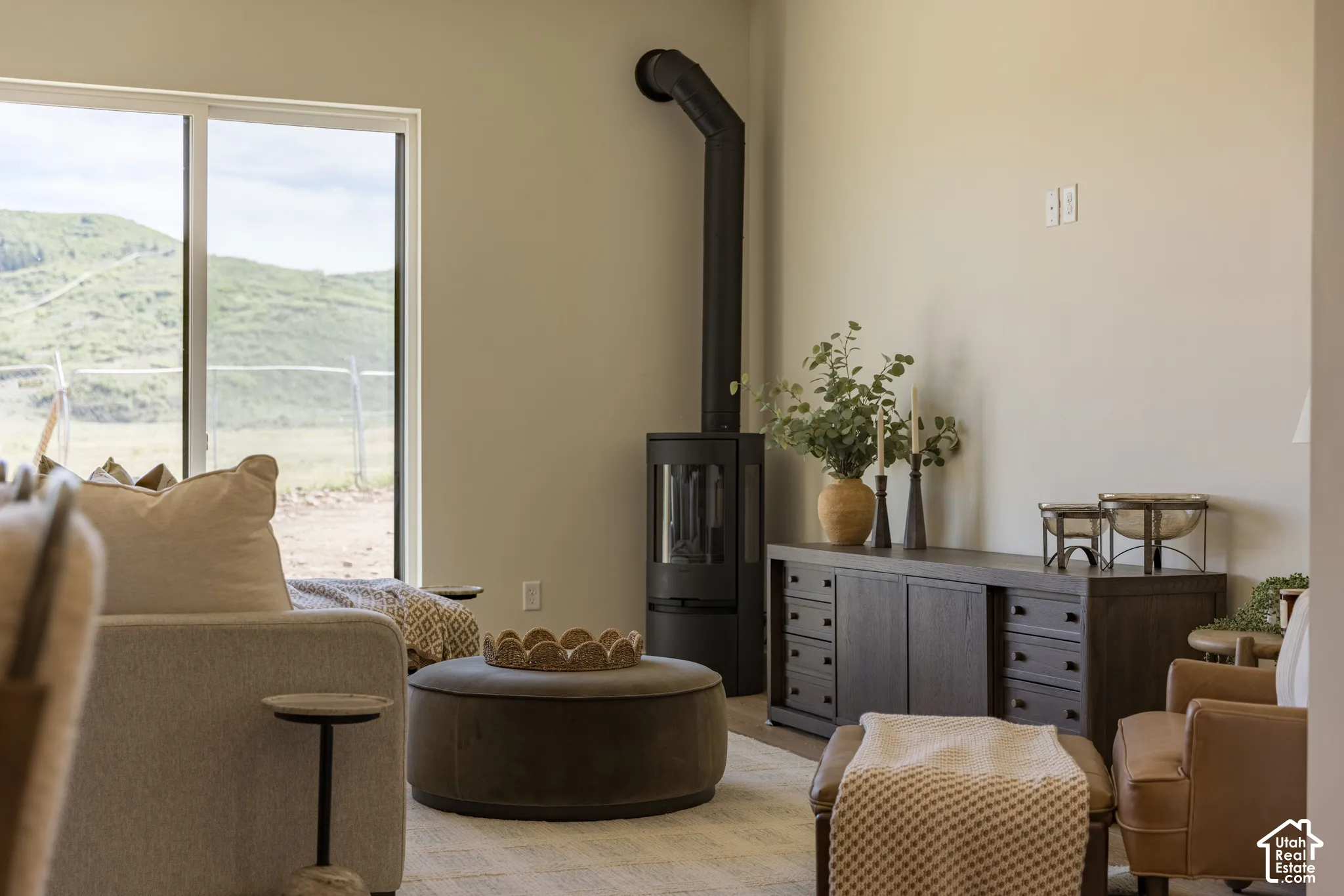 Free-standing black metal stove, large sliding glass door, and mountain backdrop