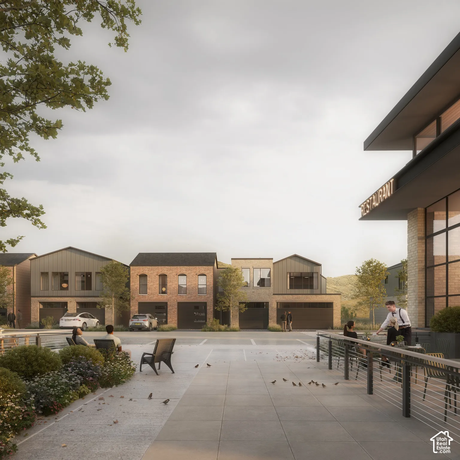 Mixed-use development featuring brick and metal-panel exterior facades, multi-level structures, paved pedestrian walkways, and integrated garage access