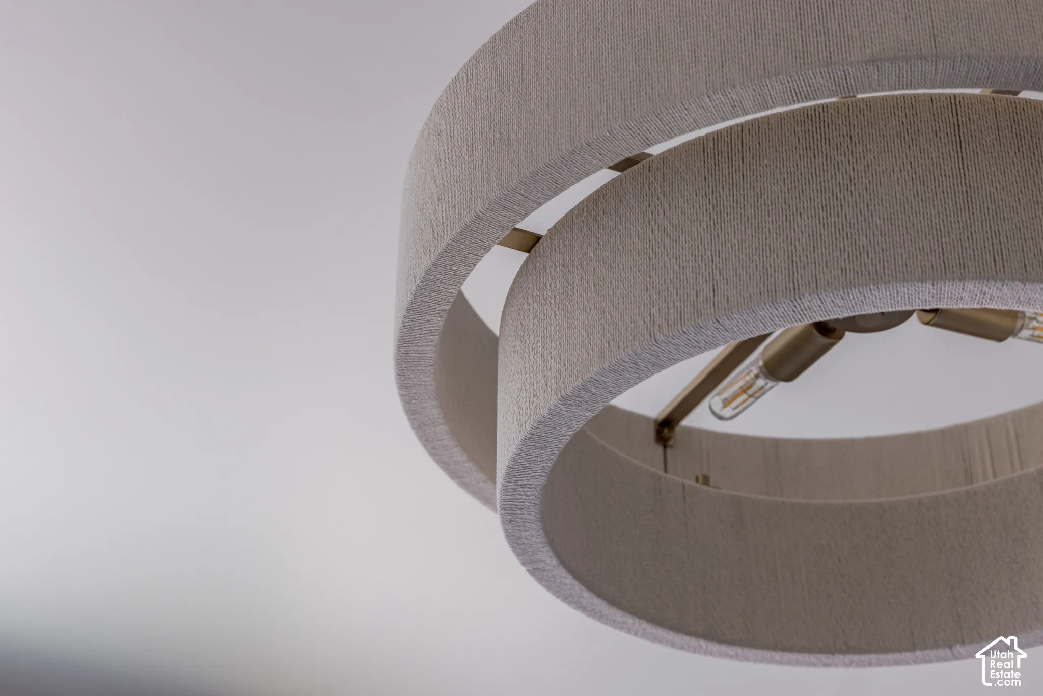 Multi-tier drum chandelier featuring a brushed metal frame and textured fabric shades