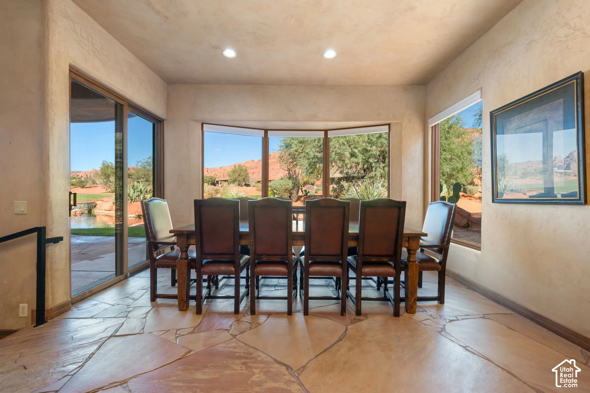 Natural stone flooring, textured wall finishes, recessed lighting, and expansive windows with desert landscape scenery