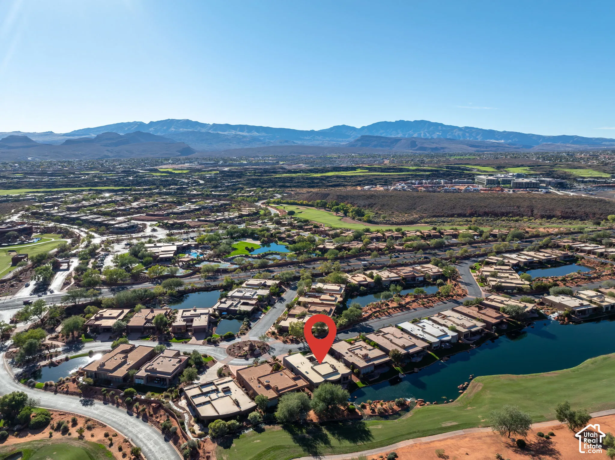 Aerial perspective featuring mountain backdrops, waterfront positioning, and proximity to golf course grounds