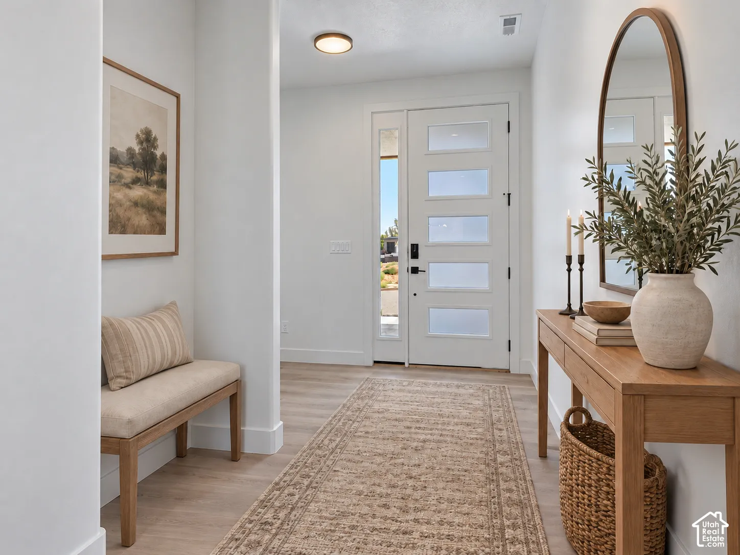 Entryway featuring wood-finish flooring, a contemporary white door with five frosted glass panels, an integrated sidelight, and a flush-mount circular ceiling fixture