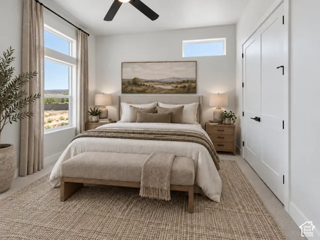 Bedroom featuring oversized windows, a clerestory window, double-door closet with matte black hardware, and a ceiling fan