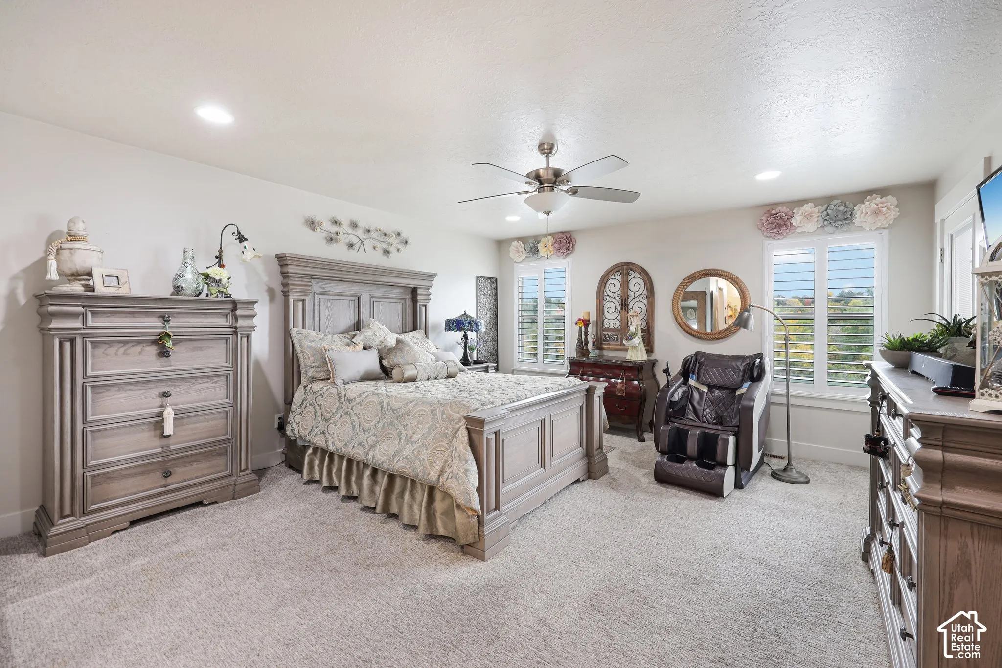 Neutral-toned room featuring recessed lighting, a brushed metal ceiling fan, and adjustable louvered shutters