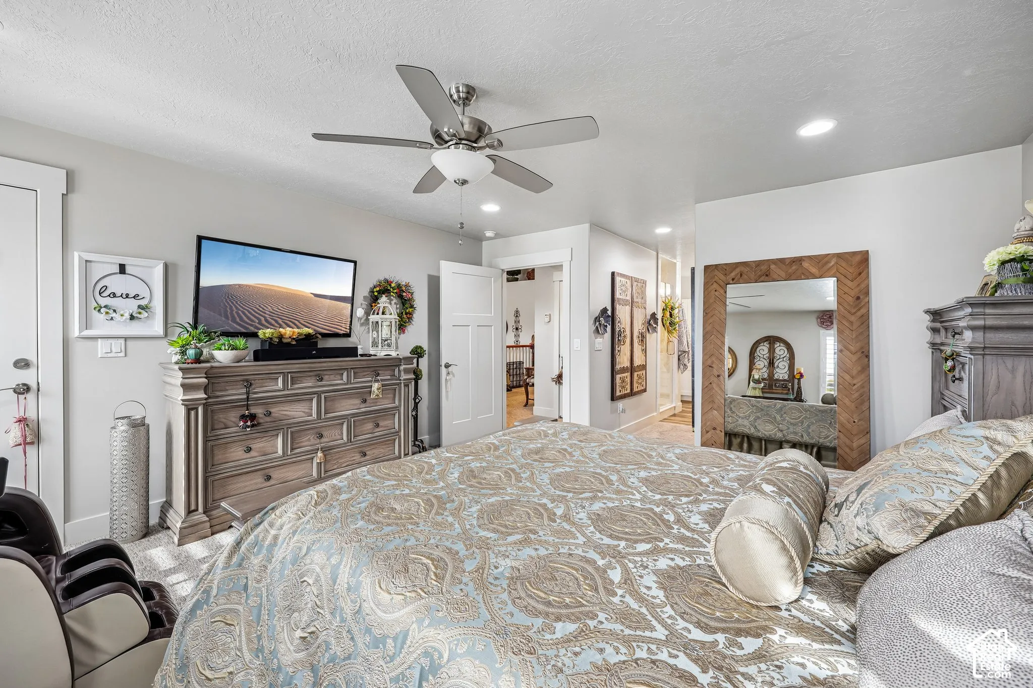 Neutral interior featuring a ceiling fan with integrated lighting, recessed ceiling lights, and shaker-style door with matching trim